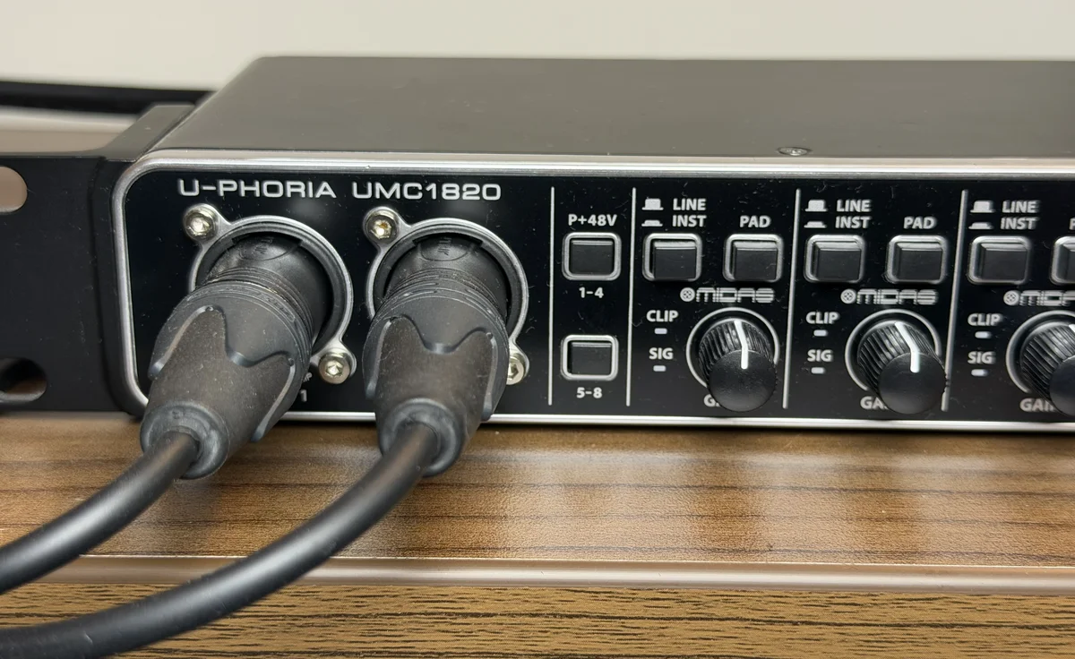 Behringer UMC1820 front panel showing the left and right ear microphone cables plugged into Inputs 1 and 2 with their gain knobs fixed
